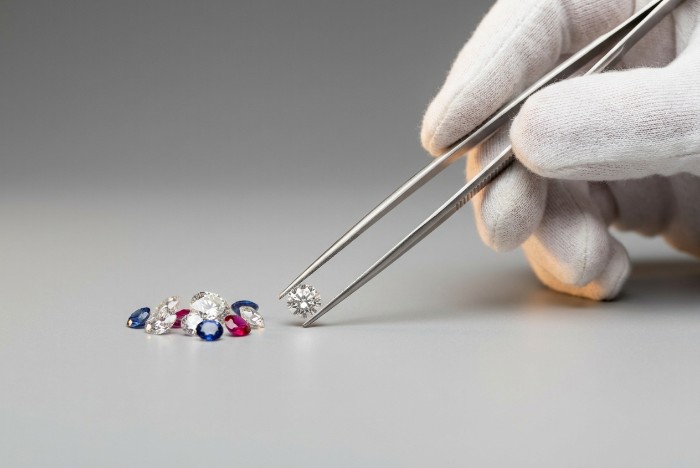 A jeweller sorts loose diamonds as AI agents in cross-border payments handle the settlement