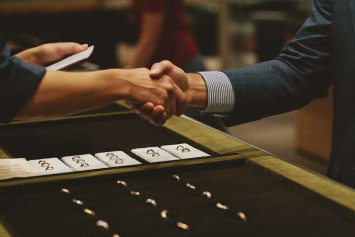 Jewellery store valuation Canada — handshake across the counter over trays of rings