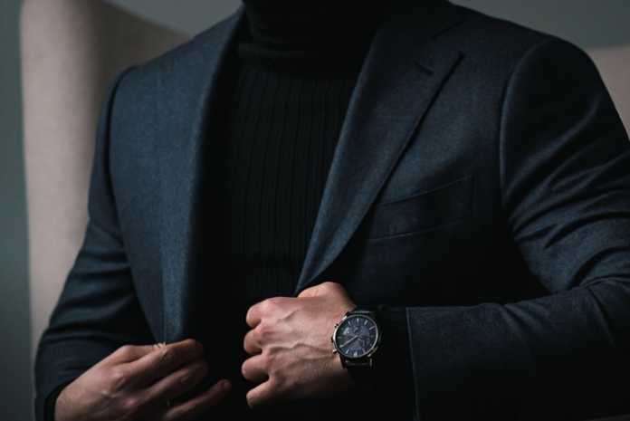 Claude Bernard watch worn on the wrist with a navy suit