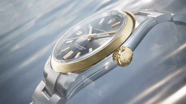 Yellow gold bezel and winding crown against the Oystersteel case of the Oyster Perpetual 41