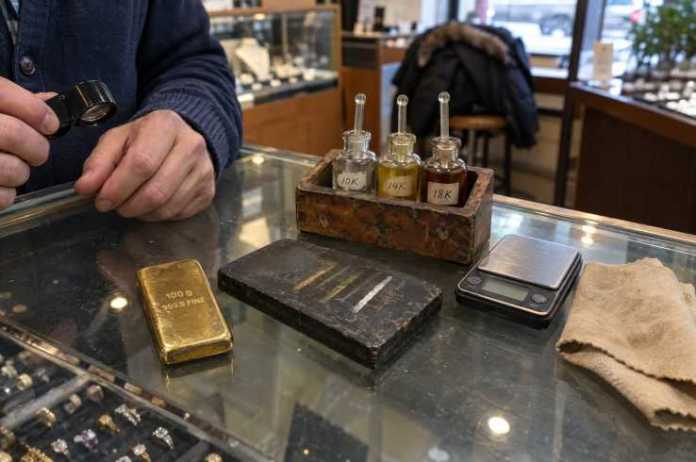 Gold bar on a jeweller's showcase with a touchstone, testing acids and a loupe